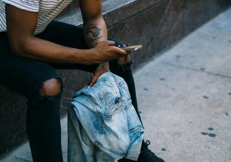 Man sat down sending payment on phone